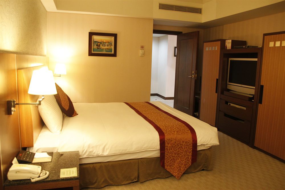 Evergreen Plaza Hotel - Тайнань Екстер'єр фото A bedroom in a hotel